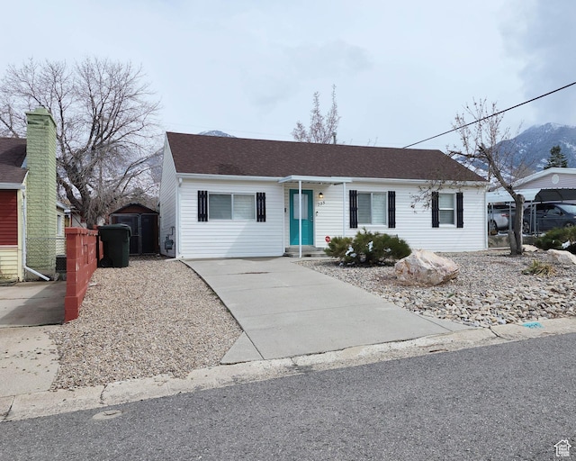 ranch-style house with a shingled roof and a mountain view