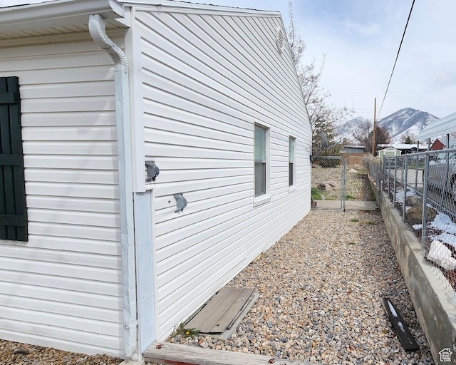 view of property exterior with a gate, a mountain view, and fence