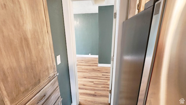 corridor featuring baseboards and wood finished floors