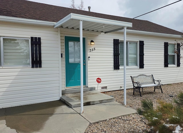 entrance to property featuring crawl space and a shingled roof
