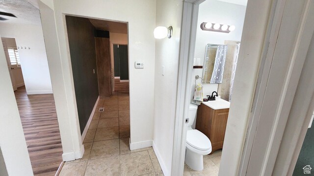 bathroom with baseboards, toilet, tile patterned floors, and vanity