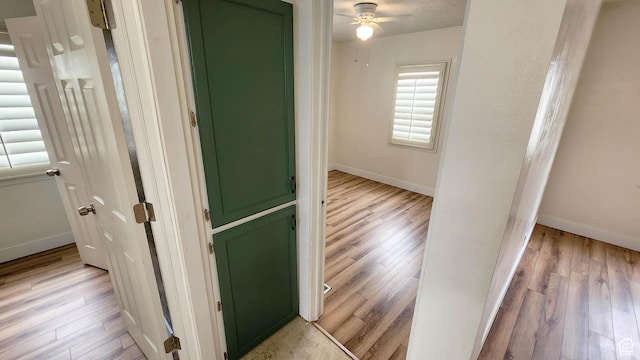 hallway with baseboards and light wood finished floors