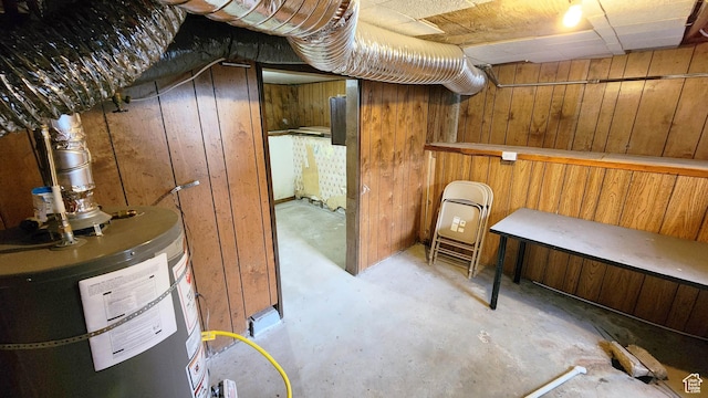 unfinished below grade area with wooden walls and gas water heater
