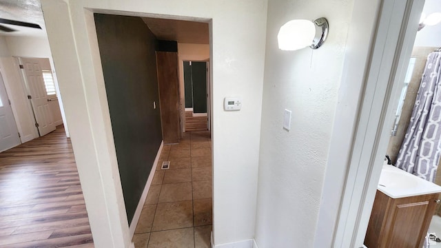hall featuring baseboards and tile patterned floors
