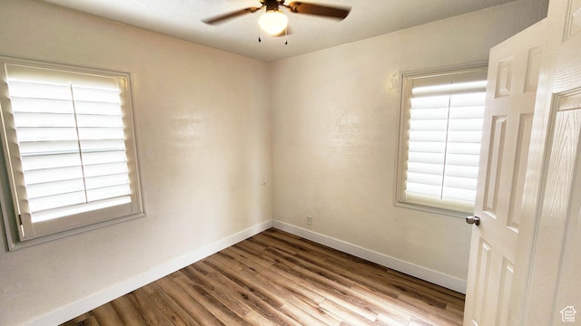empty room featuring a ceiling fan, a healthy amount of sunlight, and wood finished floors