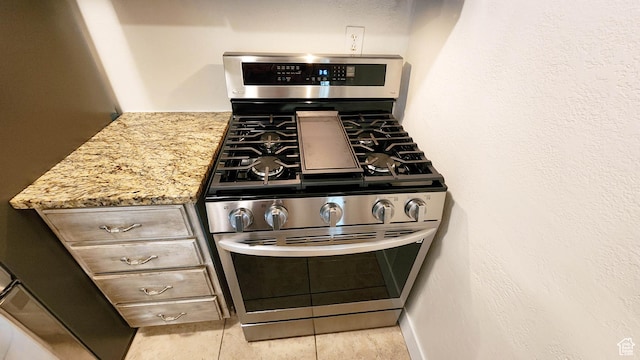 kitchen featuring gas stove and light stone countertops