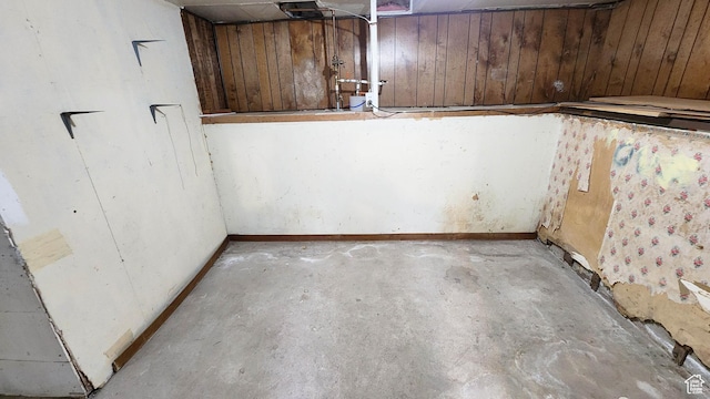 unfinished basement with baseboards and wooden walls