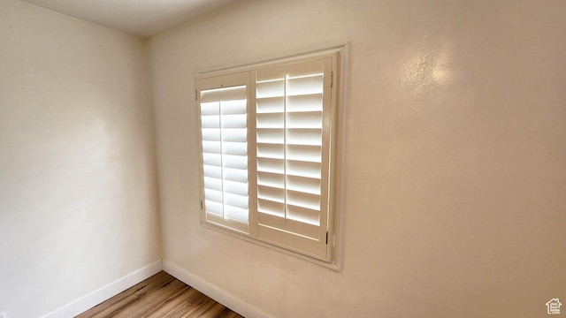 unfurnished room with baseboards and wood finished floors