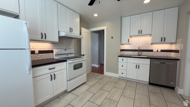 kitchen featuring white appliances, under cabinet range hood, a sink, dark countertops, and ceiling fan
