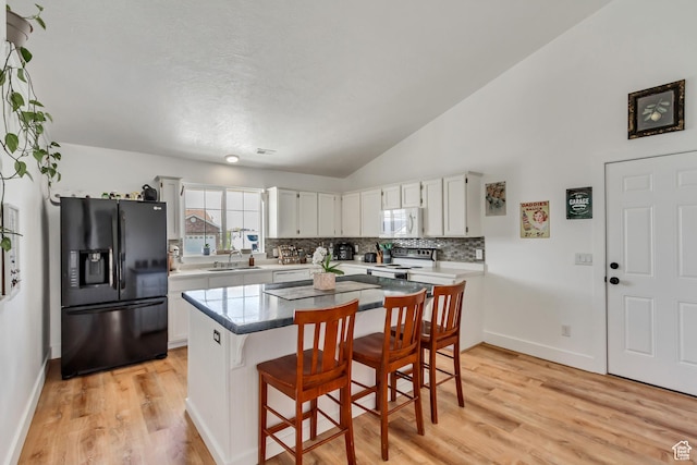 4103 S Sunrise Dr, Saratoga Springs, UT 84045 - kitchen featuring a sink, electric range oven, tasteful backsplash, black refrigerator with ice dispenser, and white microwave