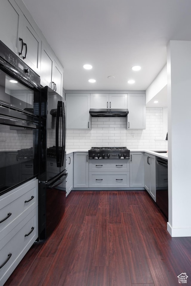 440 E Creekside Cir S Unit B, Murray, UT 84107 - kitchen with under cabinet range hood, dark wood-style floors, black appliances, and backsplash