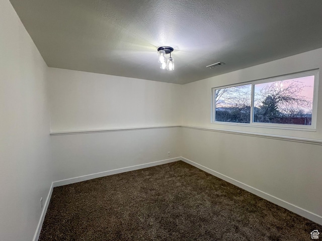 6770 W 3860 S, West Valley City, UT 84128 - spare room featuring baseboards, visible vents, dark carpet, and a textured ceiling