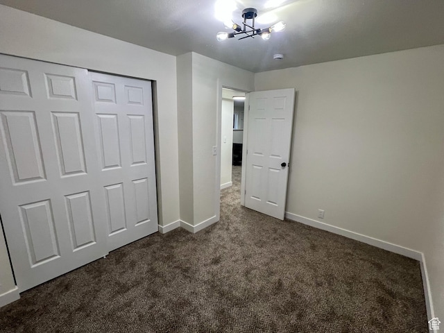 6770 W 3860 S, West Valley City, UT 84128 - unfurnished bedroom with a closet, a notable chandelier, baseboards, and dark carpet