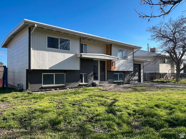 6770 W 3860 S, West Valley City, UT 84128 - back of house featuring a lawn, brick siding, a garage, and fence