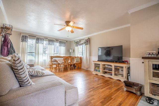 3839 S 2050 W, Roy, UT 84067 - living room featuring wood finished floors, a ceiling fan, a wainscoted wall, and crown molding