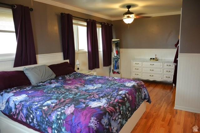 3839 S 2050 W, Roy, UT 84067 - bedroom featuring wood finished floors, a wainscoted wall, ornamental molding, and ceiling fan
