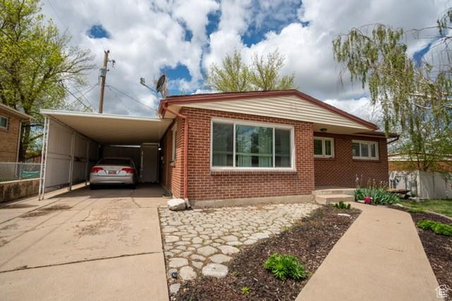3839 S 2050 W, Roy, UT 84067 - view of front of property with concrete driveway, brick siding, a carport, and fence