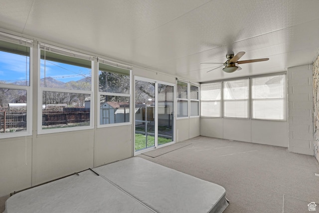 unfurnished sunroom with ceiling fan