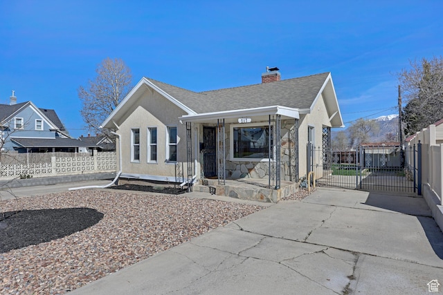 bungalow-style house featuring stucco siding, roof with shingles, fence, a gate, and a chimney