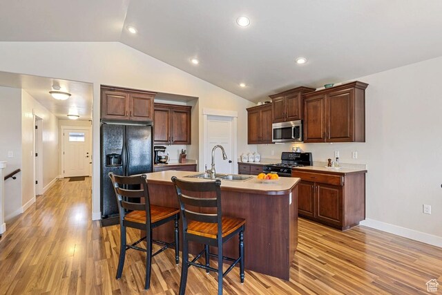 1234 S 1150 W, Payson, UT 84651 - kitchen featuring black appliances, a sink, lofted ceiling, a breakfast bar, and light wood-style floors