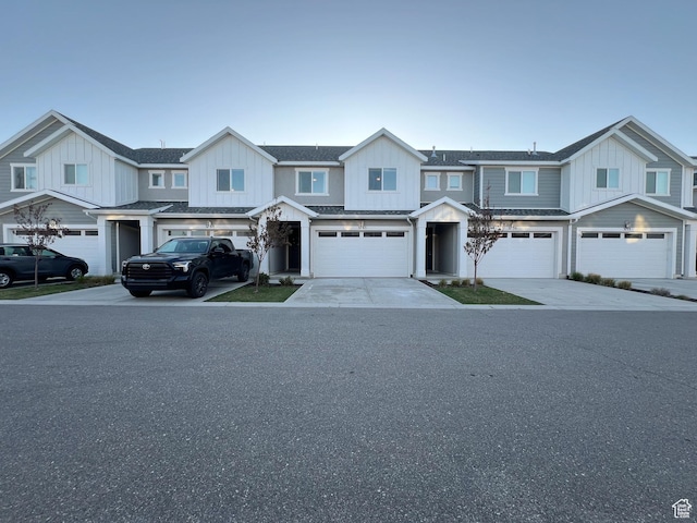 multi unit property featuring concrete driveway, board and batten siding, and an attached garage
