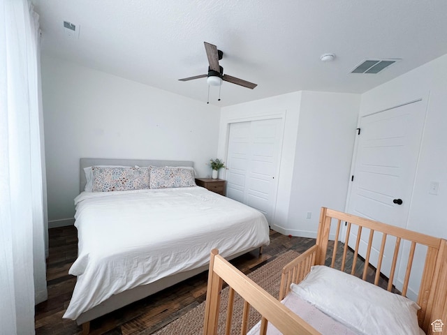 bedroom with visible vents, a closet, baseboards, and wood finished floors
