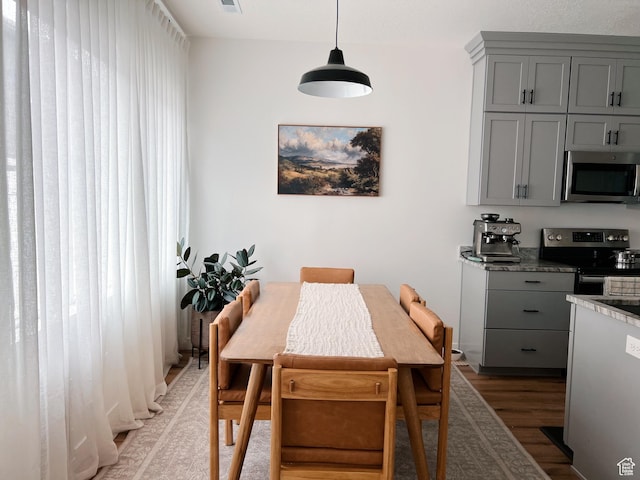 dining area with light wood-style flooring and visible vents