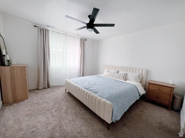 bedroom featuring visible vents, light colored carpet, and ceiling fan