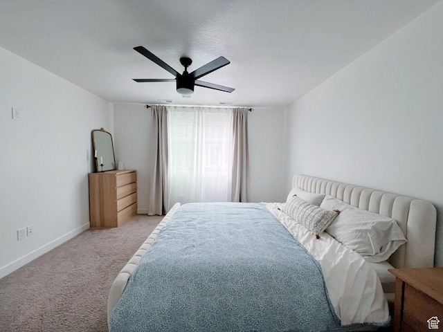 carpeted bedroom featuring baseboards and ceiling fan