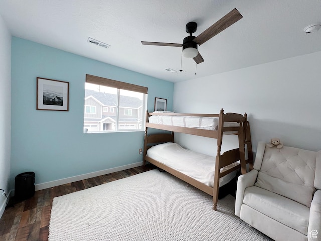 bedroom featuring wood finished floors, baseboards, a ceiling fan, and visible vents