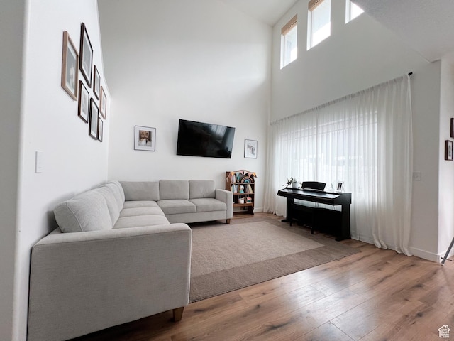 living area with a high ceiling and hardwood / wood-style floors