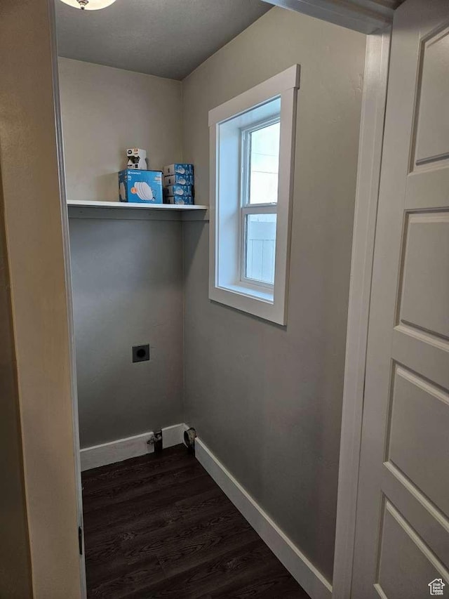 clothes washing area with laundry area, hookup for an electric dryer, baseboards, and dark wood-style floors