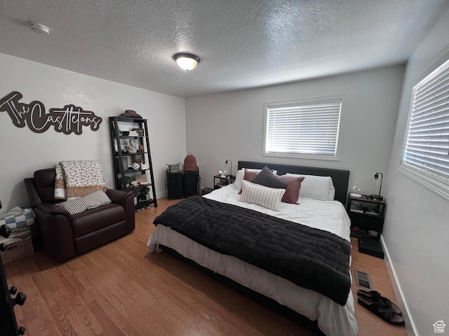 174 N 500 E, Logan, UT 84321 - bedroom featuring visible vents, baseboards, a textured ceiling, and wood finished floors