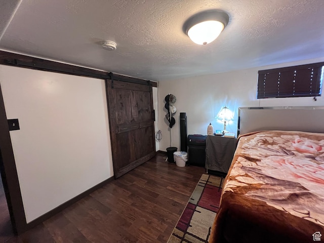 174 N 500 E, Logan, UT 84321 - bedroom with a textured ceiling, baseboards, dark wood finished floors, and a barn door