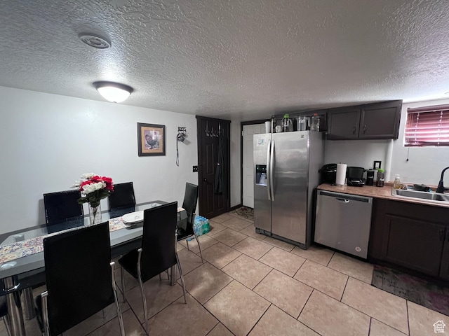 174 N 500 E, Logan, UT 84321 - kitchen featuring light tile patterned floors, a sink, light countertops, a textured ceiling, and stainless steel appliances