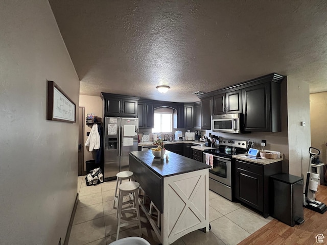174 N 500 E, Logan, UT 84321 - kitchen with a textured ceiling, light tile patterned floors, a sink, and stainless steel appliances