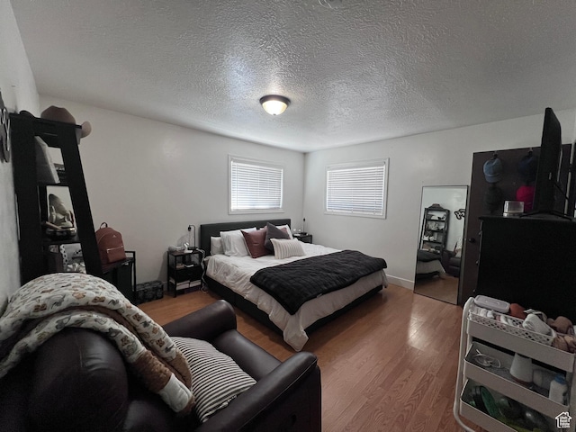174 N 500 E, Logan, UT 84321 - bedroom featuring a textured ceiling, baseboards, and wood finished floors
