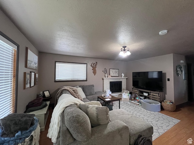 174 N 500 E, Logan, UT 84321 - living room featuring a brick fireplace, a textured ceiling, and wood finished floors