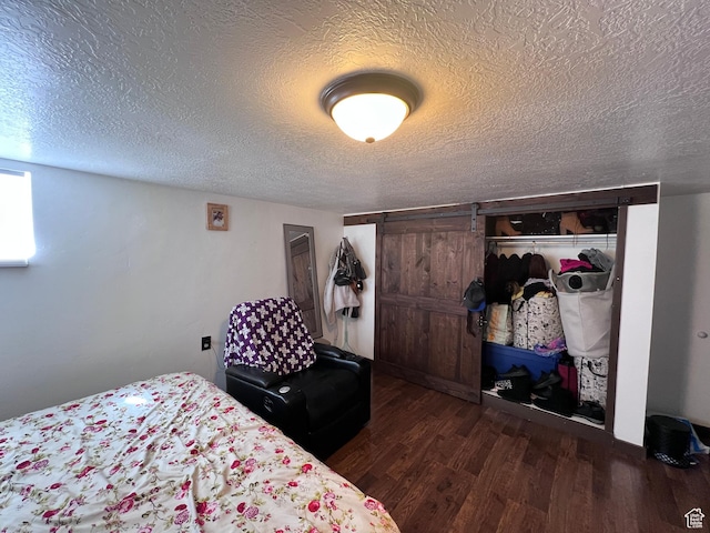 174 N 500 E, Logan, UT 84321 - bedroom featuring a barn door, a closet, a textured ceiling, and wood finished floors