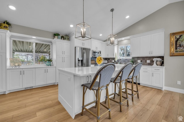 945 E Diana Way, Sandy, UT 84094 - kitchen with light wood-style flooring, light countertops, white cabinetry, appliances with stainless steel finishes, and pendant lighting