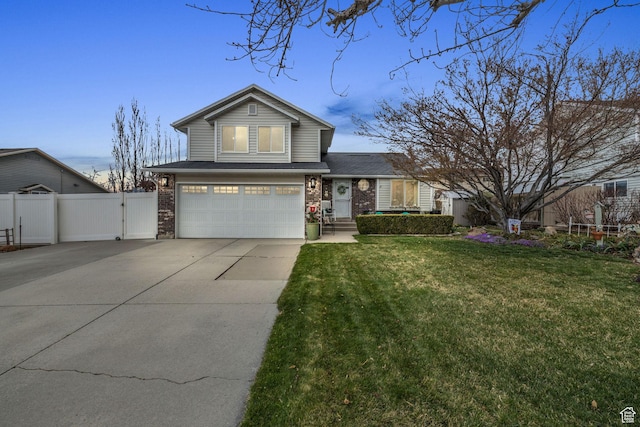 traditional-style house featuring an attached garage, fence, concrete driveway, brick siding, and a front lawn