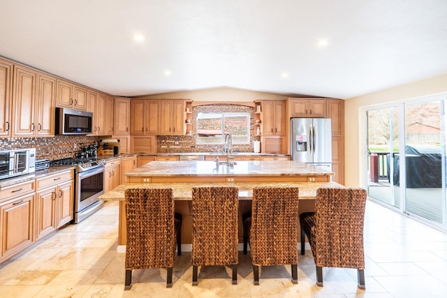 69 E Coronado Ln, Moab, UT 84532 - kitchen featuring open shelves, appliances with stainless steel finishes, an island with sink, vaulted ceiling, and decorative backsplash
