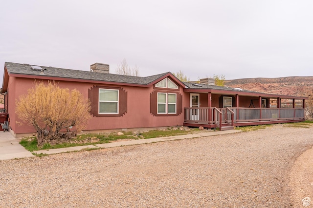69 E Coronado Ln, Moab, UT 84532 - ranch-style home with a shingled roof, a chimney, and covered porch