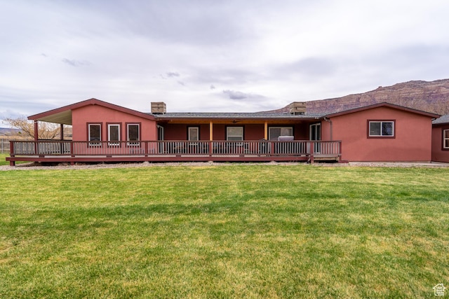 69 E Coronado Ln, Moab, UT 84532 - back of house featuring a yard, a deck, and stucco siding