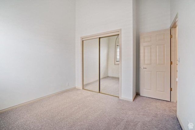 unfurnished bedroom featuring baseboards, carpet flooring, and a closet