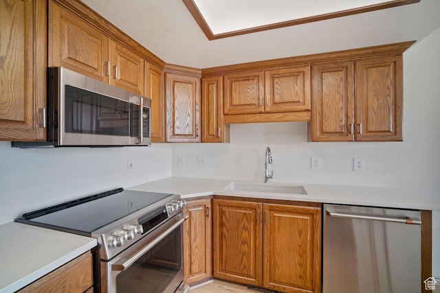 kitchen with stainless steel appliances, a sink, and brown cabinetry