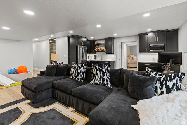 11534 S Rk Cv, South Jordan, UT 84095 - living room featuring recessed lighting, bar with sink, light wood-type flooring, and baseboards