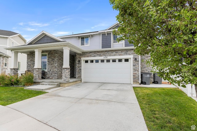 11534 S Rk Cv, South Jordan, UT 84095 - view of front facade with covered porch, concrete driveway, a front yard, and an attached garage