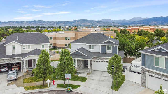 11534 S Rk Cv, South Jordan, UT 84095 - view of front of property featuring stone siding, concrete driveway, a mountain view, fence, and an attached garage