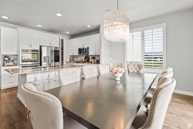 11534 S Rk Cv, South Jordan, UT 84095 - dining space featuring wood finished floors, a chandelier, recessed lighting, and baseboards